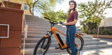 Frau mit orangefarbenem Fahrrad