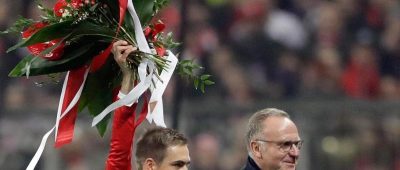 Philipp Lahm (l) erhält von Bayern-Vorstandschefs Karl-Heinz Rummenigge nachträglich Blumen für sein 500. Pflichtspiel. Foto: Matthias Schrader