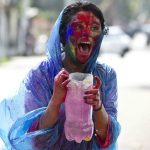In Indien wird beim Holi-Festival auch farbiges Wasser auf andere ausgeschüttet. Foto: Anupam Nath/AP/dpa.