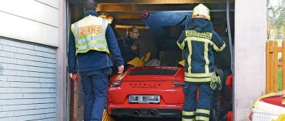 Nachdem der Porsche 911 zunächst drei parkende Autos und mehrere Gartenmauern beschädigt hatte, durchbach er ein Garagentor. Foto: BeckerBredel