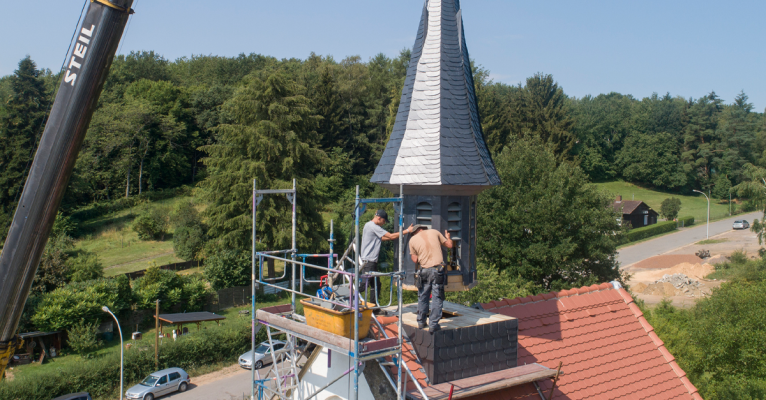 Dominik Blankenberg und sein Sohn Leon bringen den Turm der Wendalinuskapelle in Ludweiler in Position. Foto: BeckerBredel