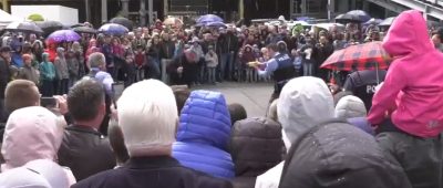 In einem Video der Polizei Saarland ist zu sehen, wie ein Beamter zur Vorführung mit einem Taser auf einen Mann feuert. Im Publikum sind Kinder zu erkennen. Screenshot: Facebook/Polizei Saarland.