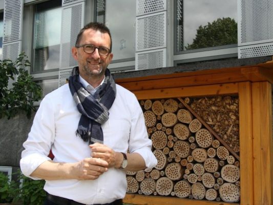Reinhold Jost (SPD), Umweltminister des Saarlandes, steht vor seinem Ministerium an einem Insektenhotel. Foto: Katja Sponholz