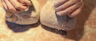 Ein Bäcker formt mit seinen Händen zwei Brote. Foto: Jan Woitas/dpa-Zentralbild/dpa/Symbolbild
