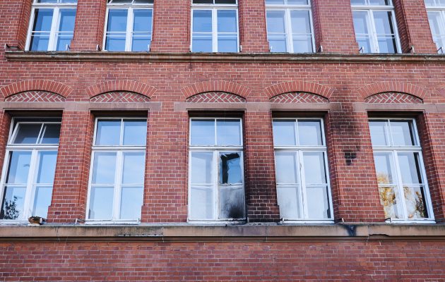 Eine zerbrochene Fensterscheibe und Rußspuren sind am Gebäude des Robert Koch-Instituts zu sehen. Laut Polizei wurde das Gebäude in der Nacht zu Sonntag mit Flaschen und Brandsätzen beworfen. Foto: Annette Riedl/dpa-Bildfunk