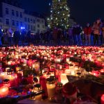 Menschen gedenken vor der Porta Nigra der Opfer der Amokfahrt und stellen Kerzen ab. Foto: picture alliance/dpa/Harald Tittel